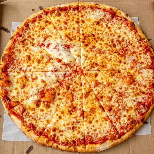 A large, freshly baked cheese pizza with golden crust, sliced into many pieces, in a cardboard box.